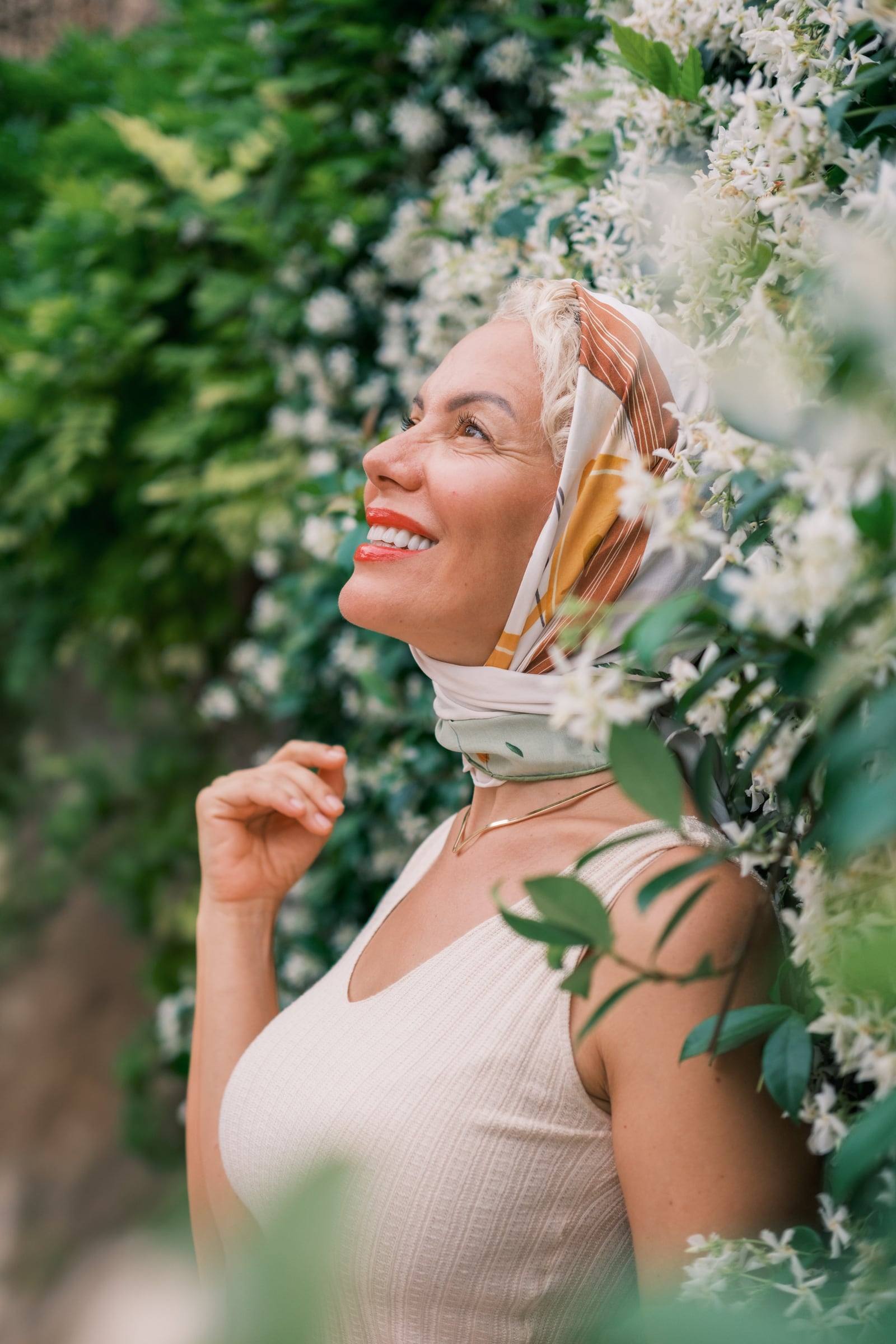 Woman in a silk scarf among white jasmine flowers