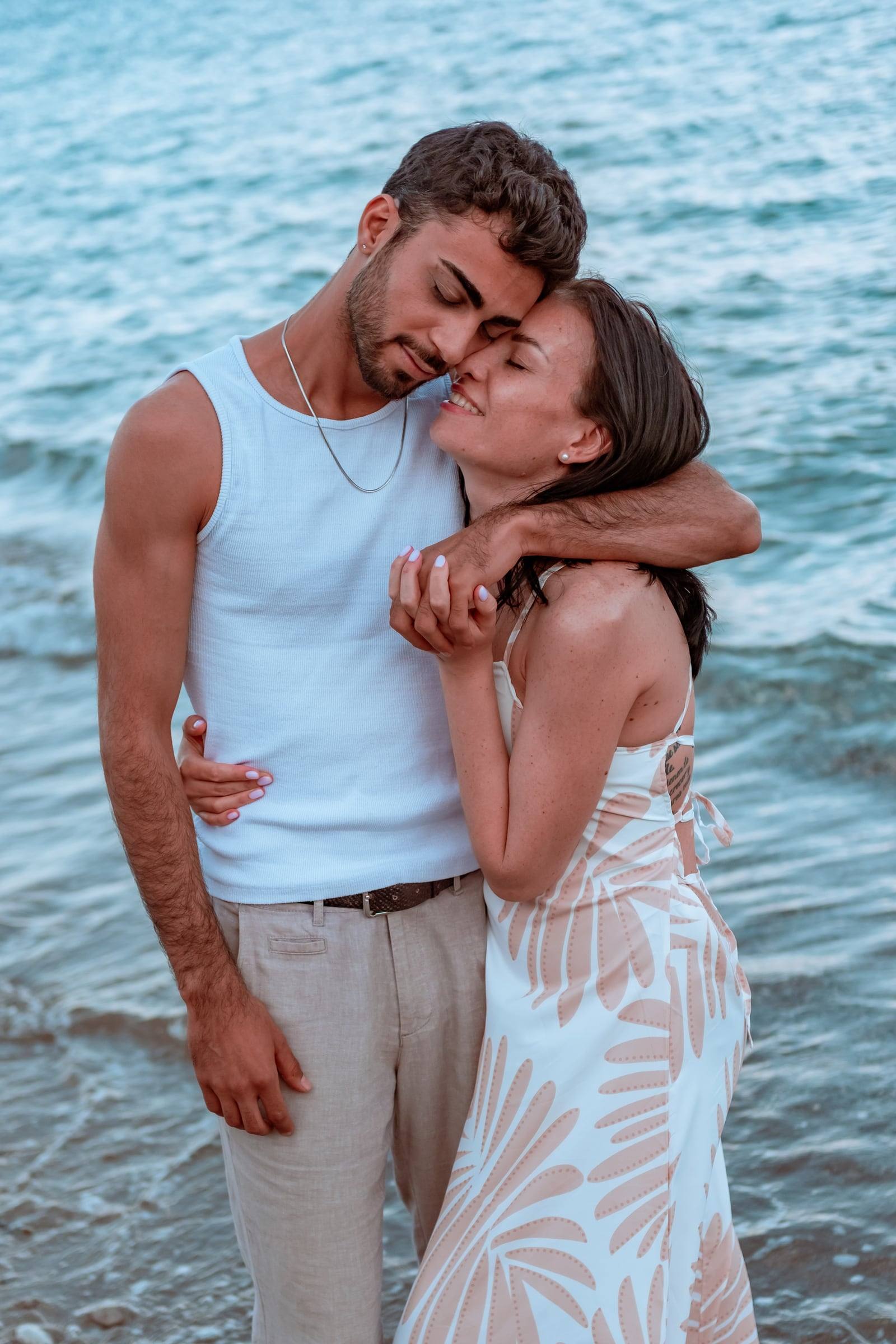 Couple embracing in the sea at golden hour
