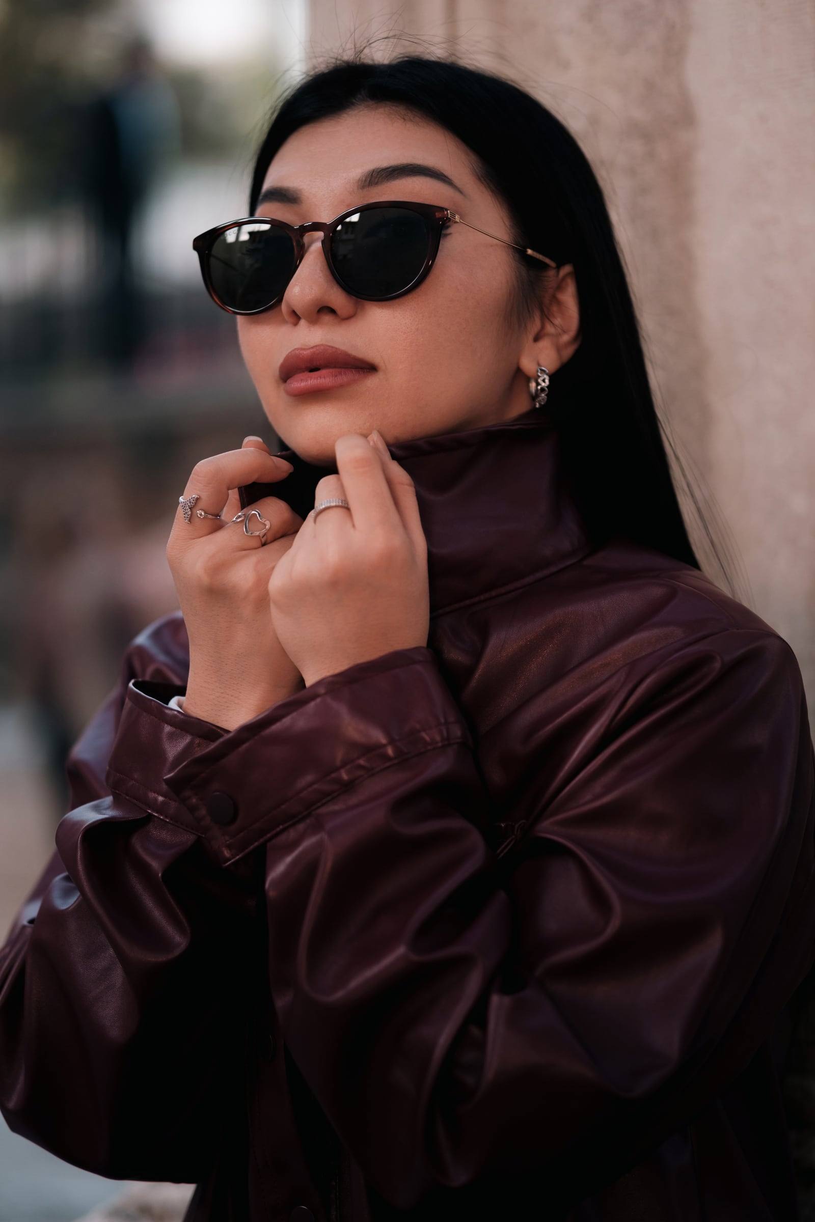 Close-up of a woman in sunglasses and a burgundy jacket