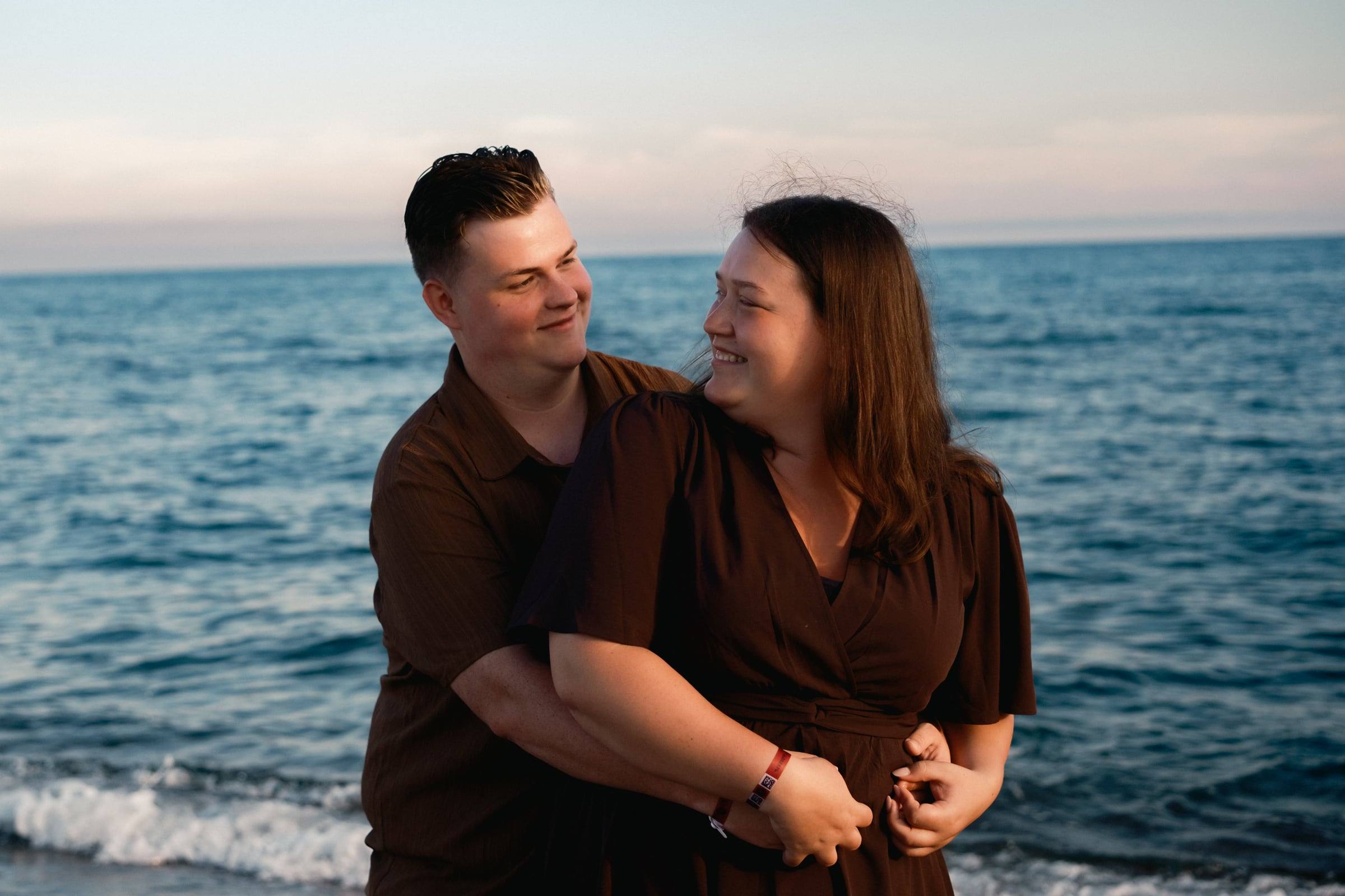 Smiling couple hugging by the sea