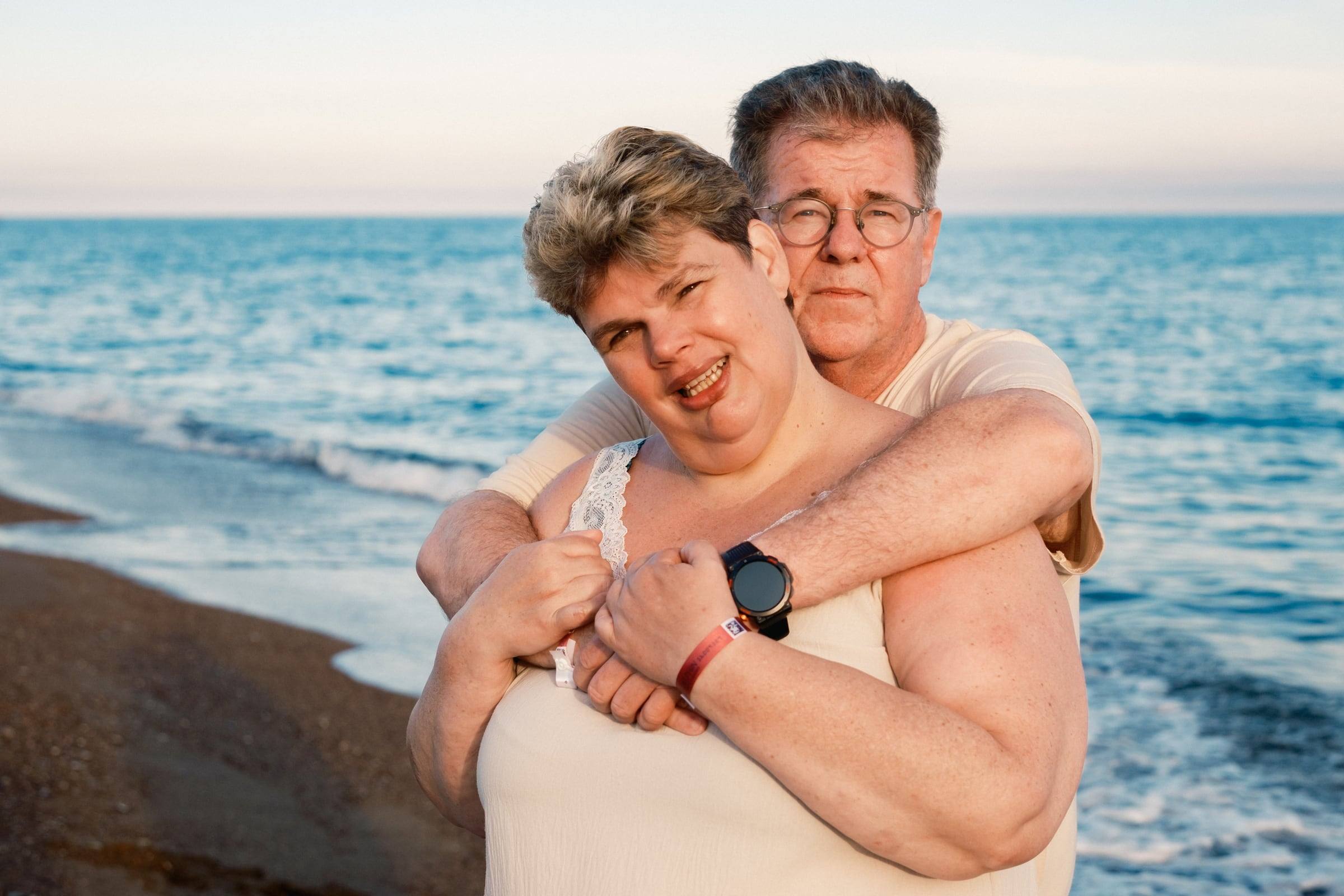 Older couple hugging happily by the sea
