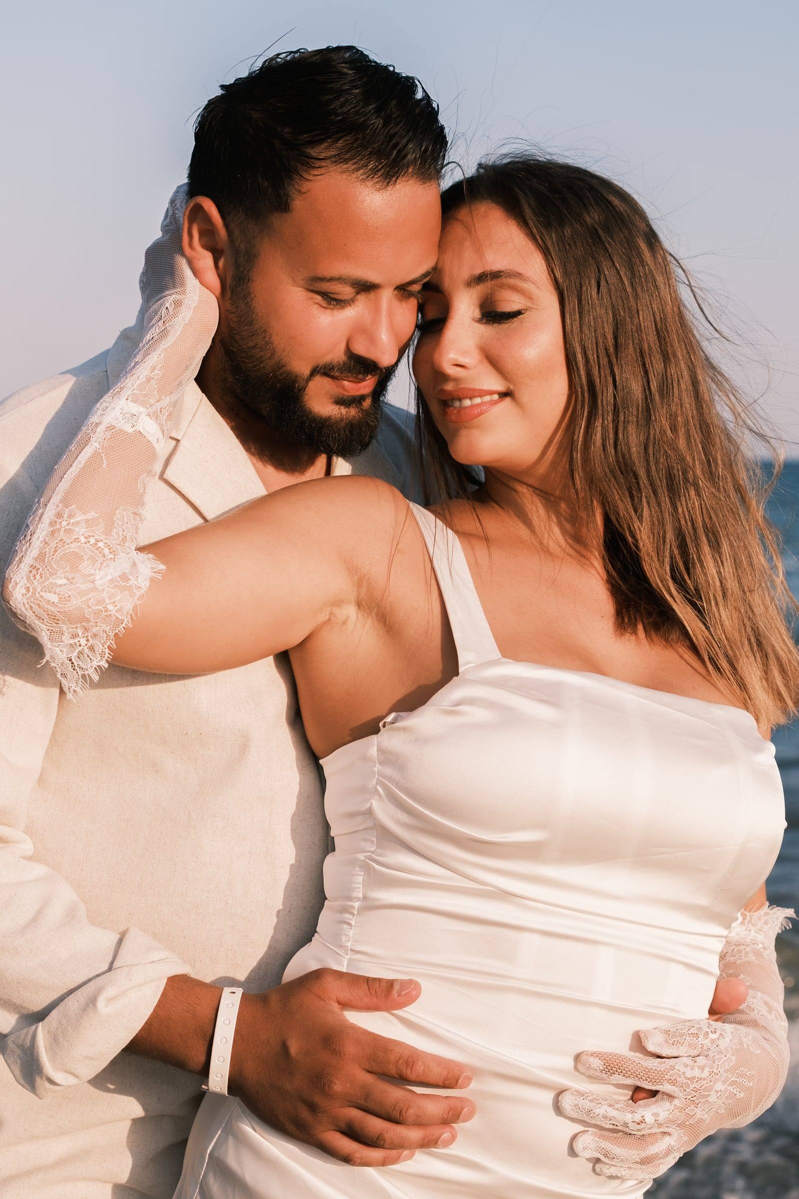 Bride and groom embracing on the beach