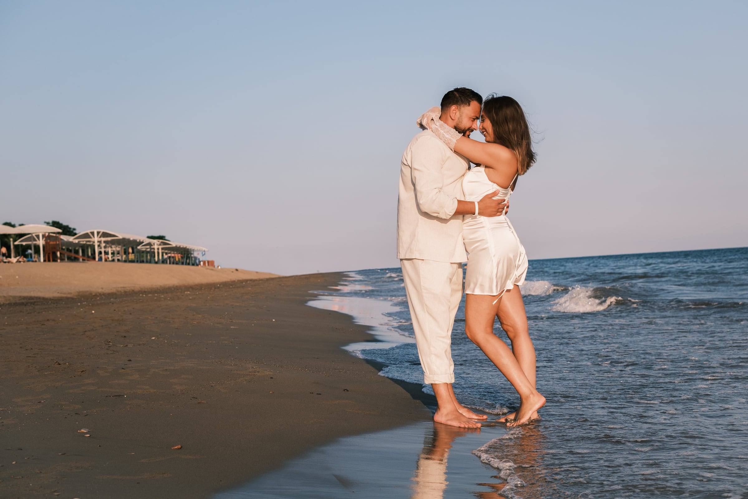 Couple kissing barefoot at the water's edge