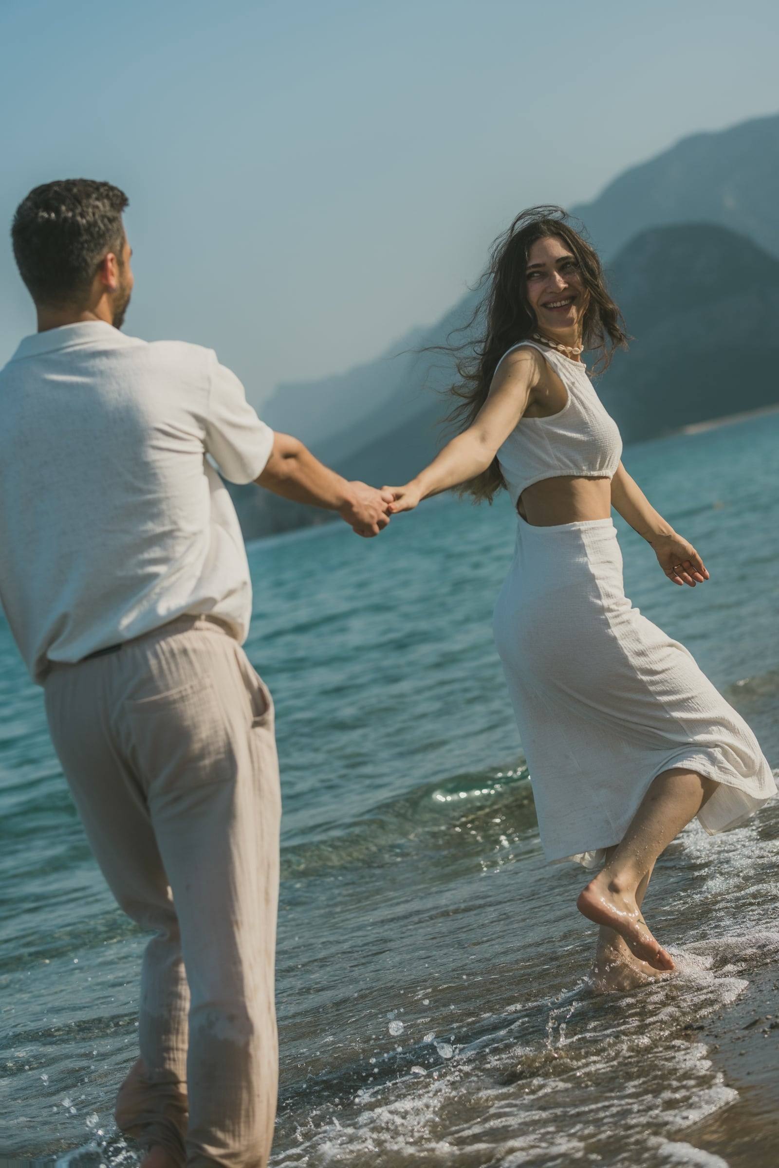 Couple walking hand in hand through the shallow water