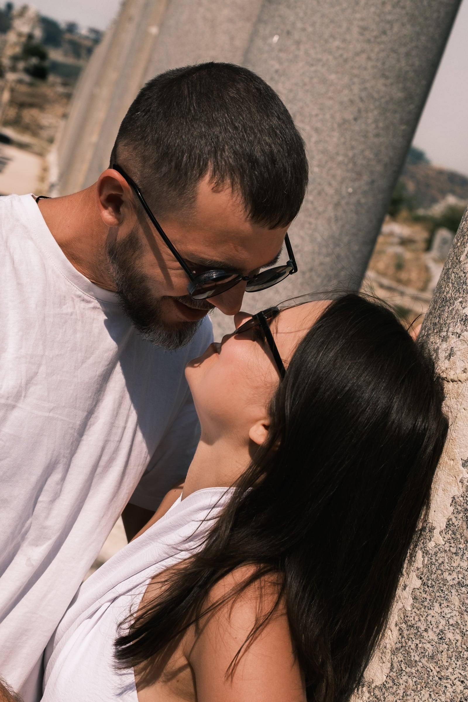 Close-up of a couple about to kiss by a marble column