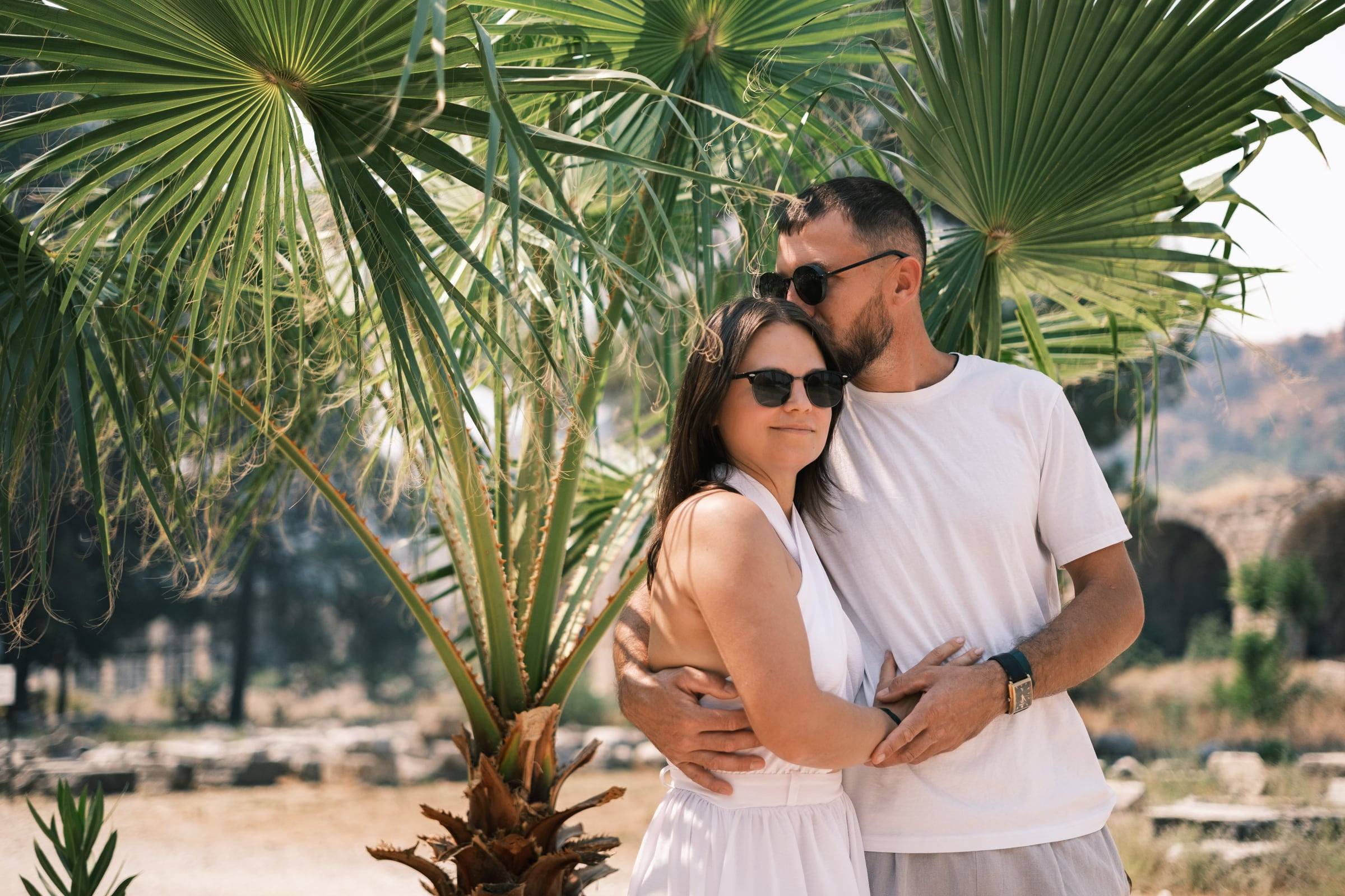 Couple under a palm tree among the ruins of Perge