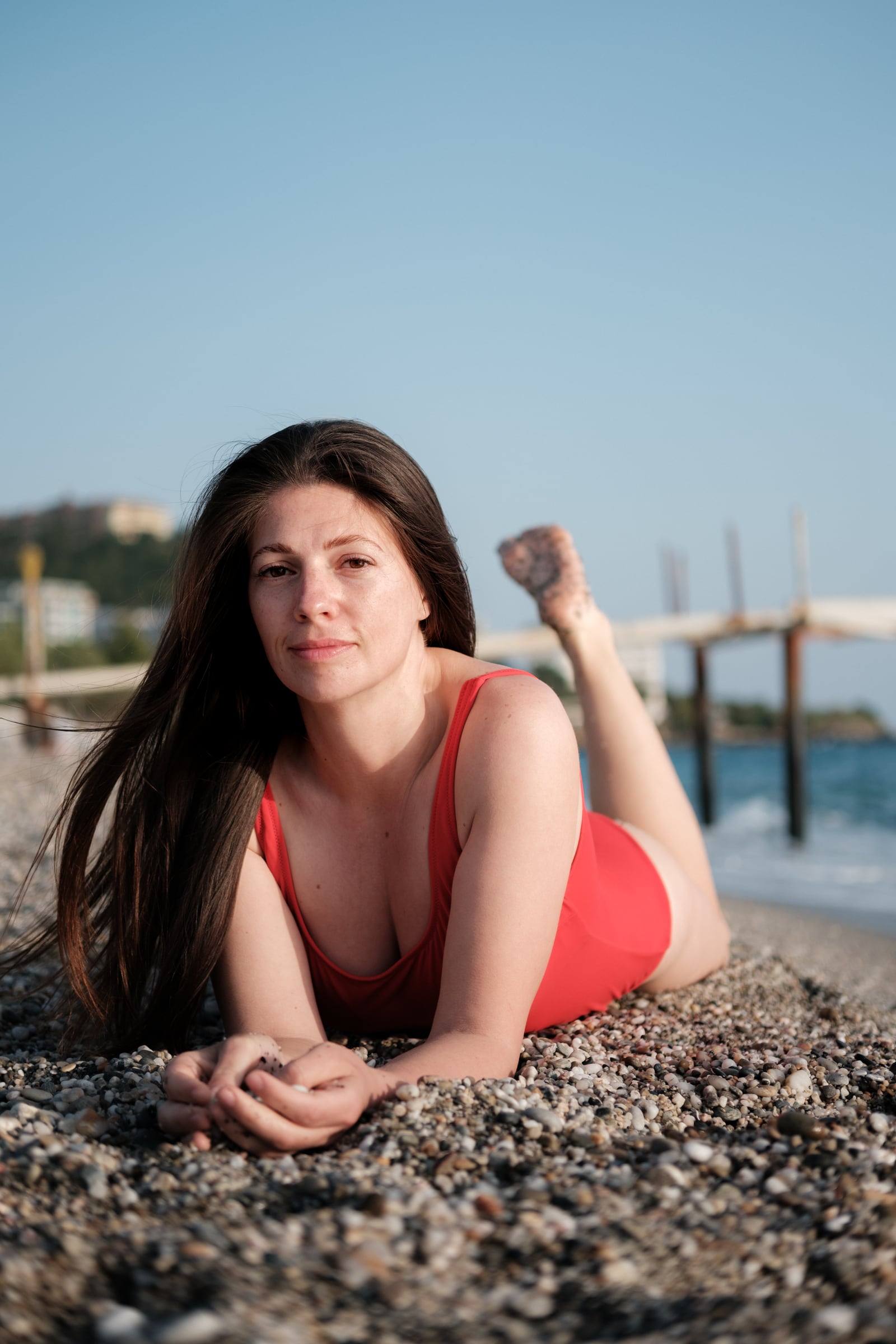 Woman in a red swimsuit lying on the sand