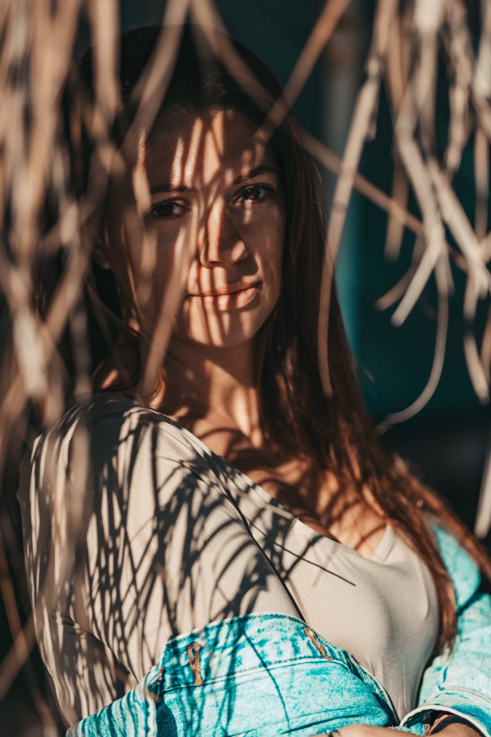 Woman with shadows of dry grass across her face