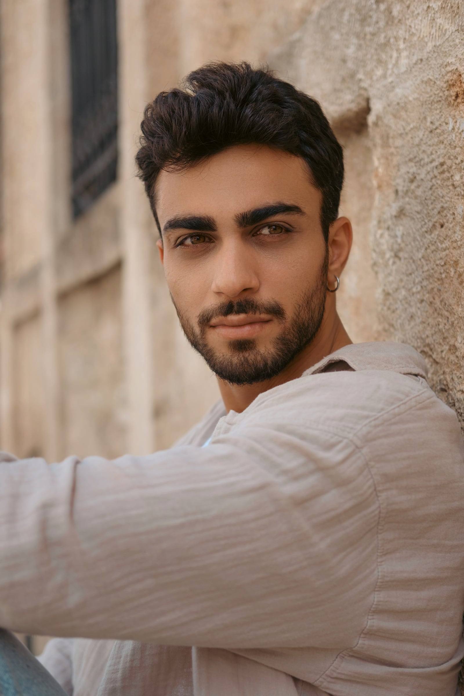 Portrait of a young man against a sandstone wall