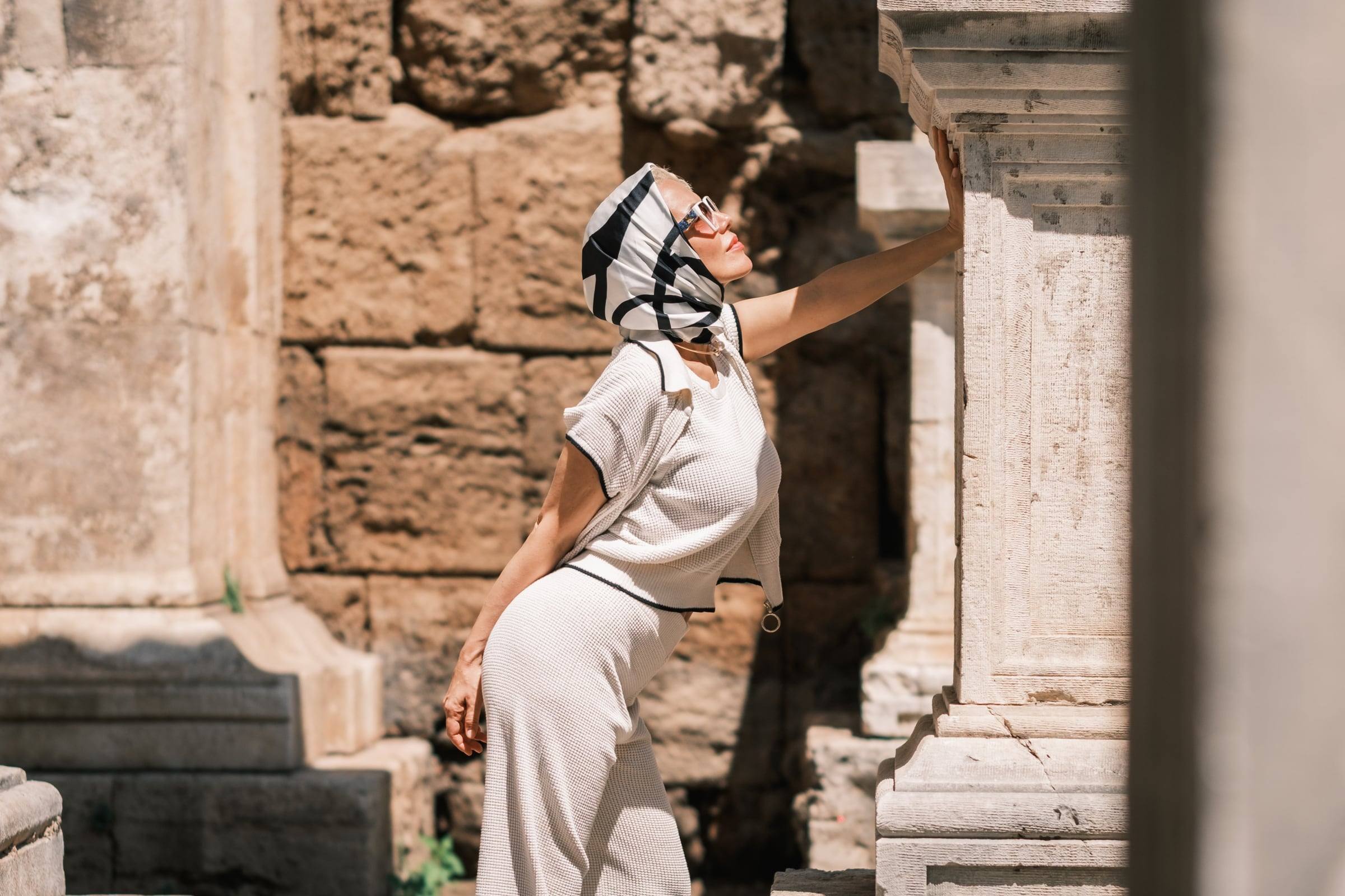 Woman in a headscarf posing between the stone pillars